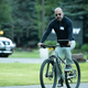 Dara Khosrowshahi using some sort of tablet while riding a bike, a photo I will never get sick of looking at